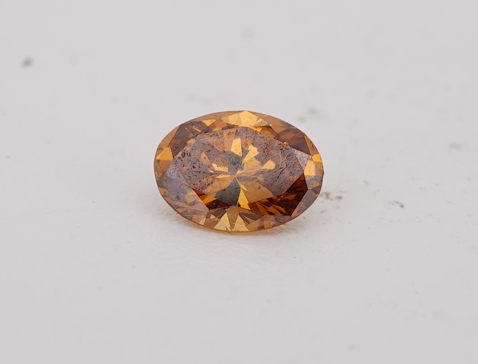An unmounted Fancy Deep Brown-Orange diamond, the oval natural diamond measuring 5.3 x 3.9 x 2.5mm, with treated colour, weighing 0.34 carats, Accompanied by GIA report no. 6233434030, stating that the Fancy Deep Brown-O
